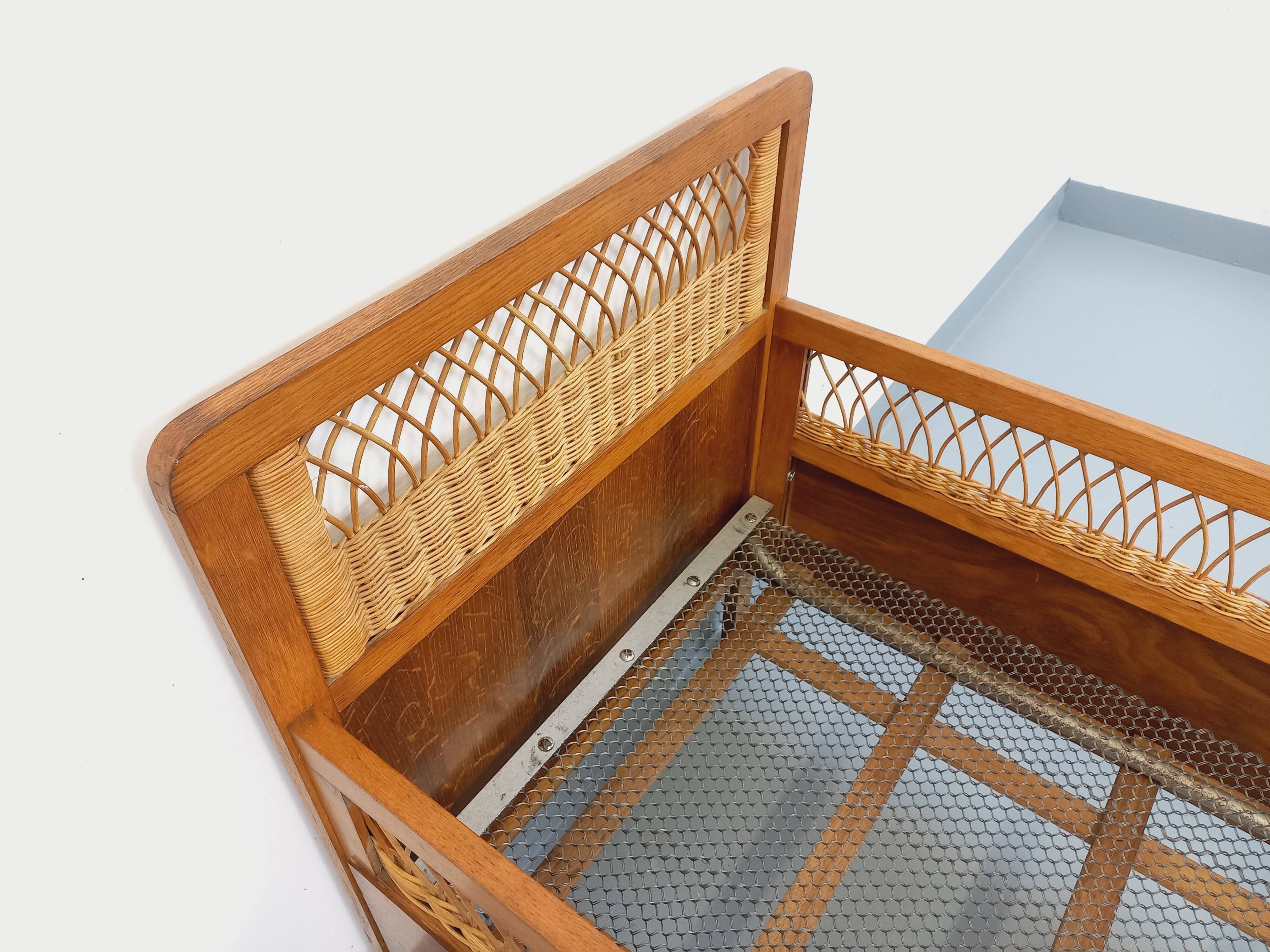 Vintage oak and rattan baby cot from the 1960s.