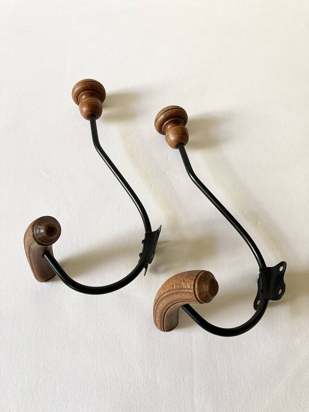 Pair of antique wooden and metal coat hooks