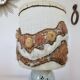 Ceramic lamp with double lighting and openwork design.