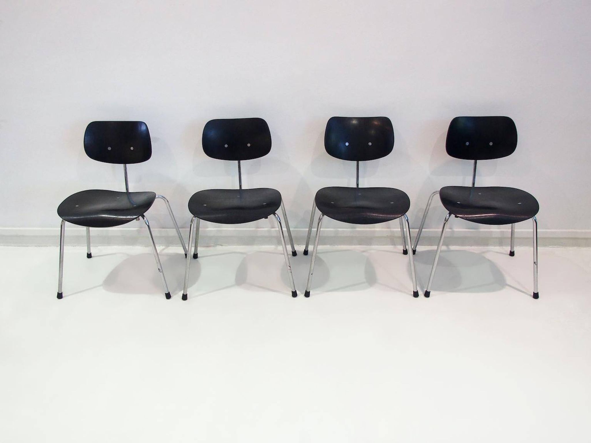 Set of four Egon Eiermann model SE 68 chairs in black lacquered plywood and steel.