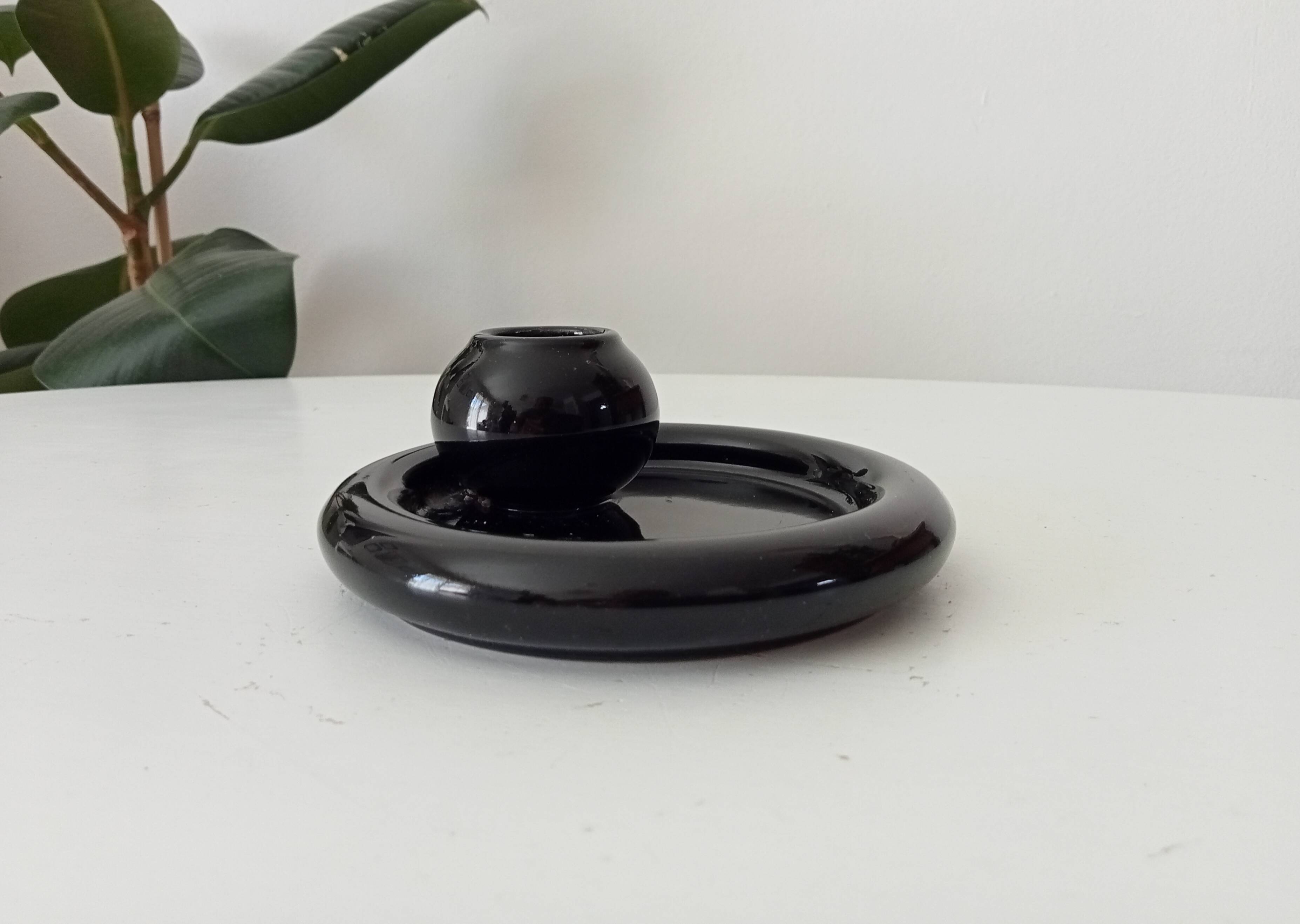 Vintage black ceramic candle holder on a bowl