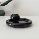Vintage black ceramic candle holder on a bowl
