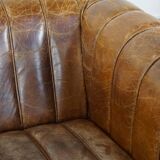 Cognac-colored cowhide 2-seater designer sofa finished with piping