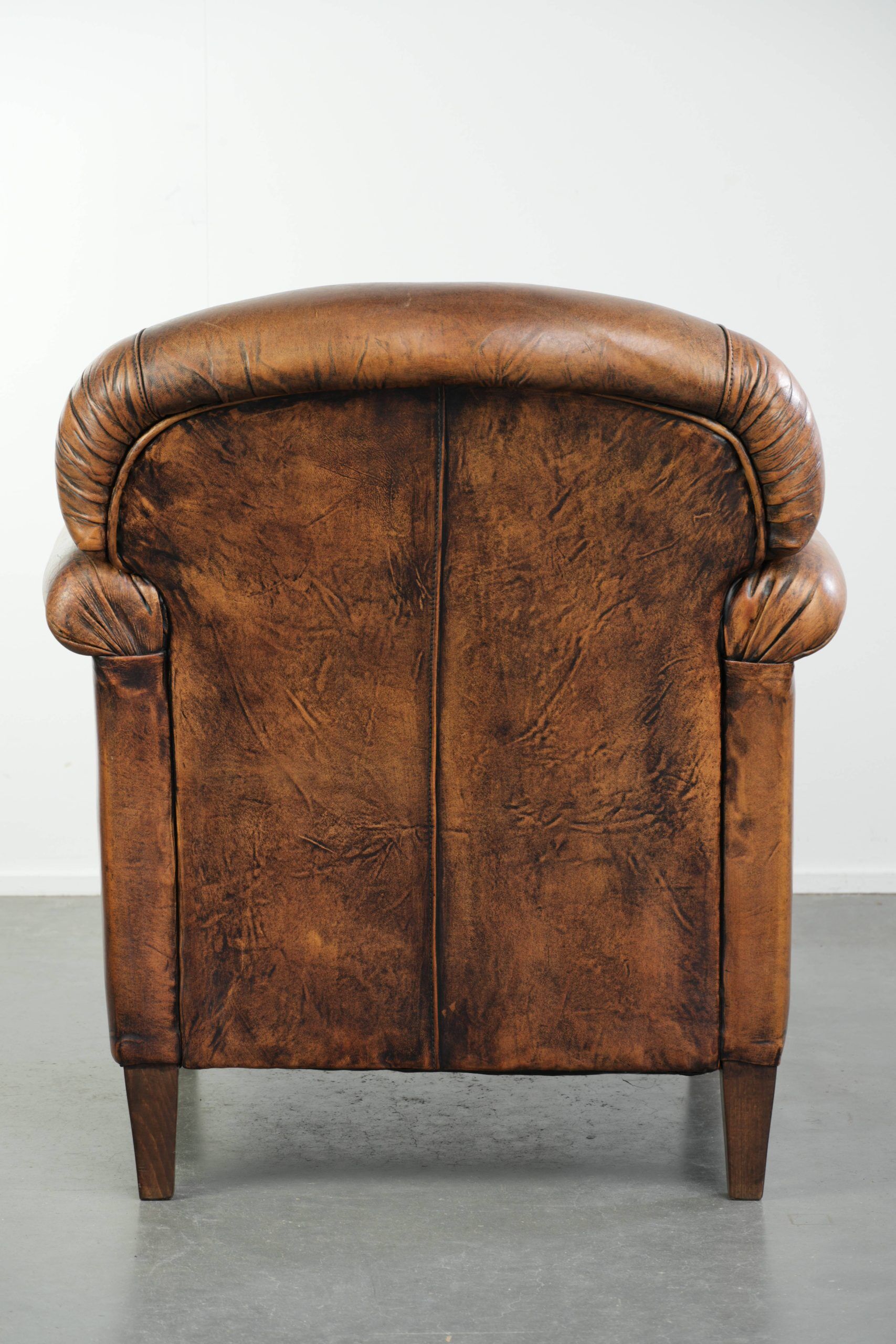 Comfortable characterful sheepskin armchair finished with decorative nails