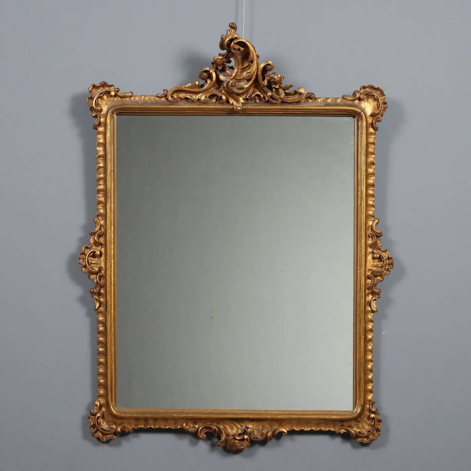 Antique Rococo-style mirror in carved gilded wood, 20th century.