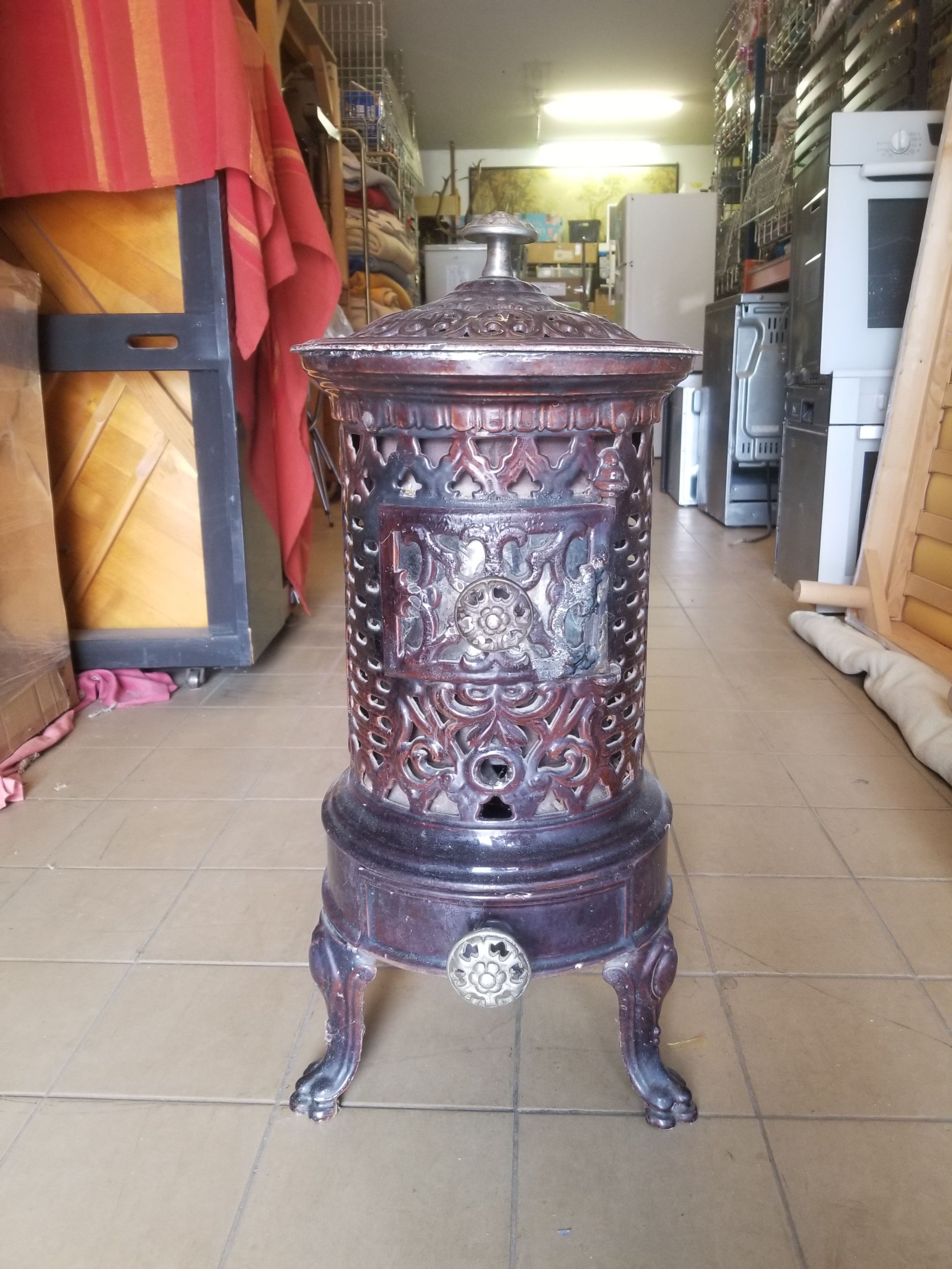 Old compact wood stove in enamelled cast iron with tripod feet with Lion's legs