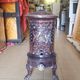 Old compact wood stove in enamelled cast iron with tripod feet with Lion's legs