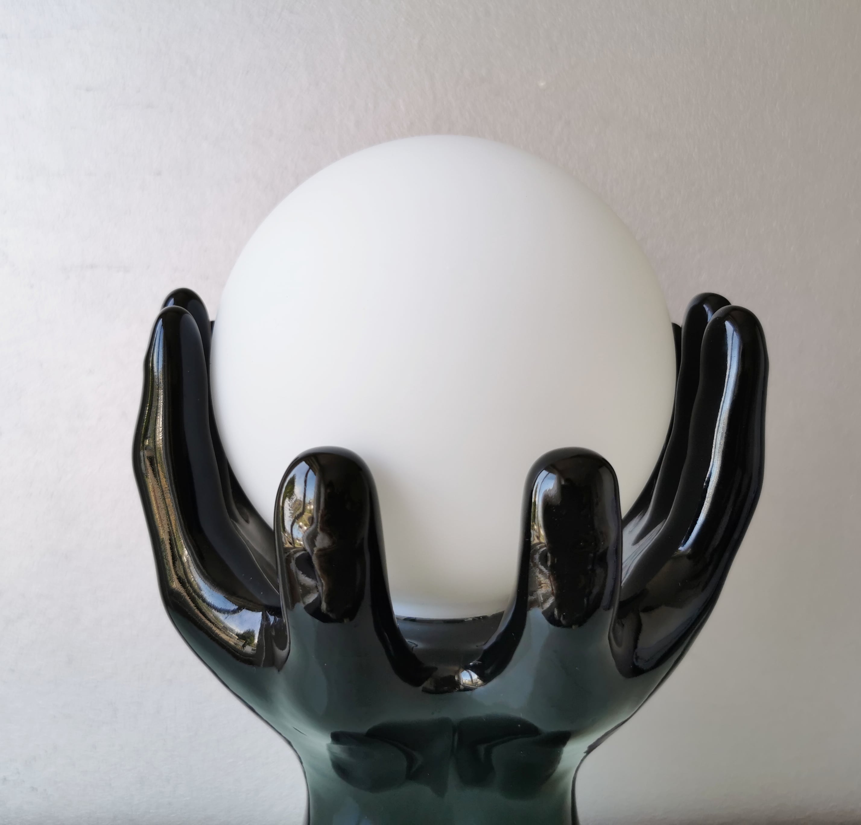 Italian design ceramic table lamp, two hands and glass shade.