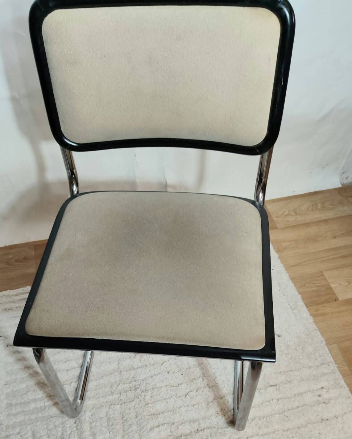 Cesca B32 chair by Marcel Breuer, upholstered in beige fabric.