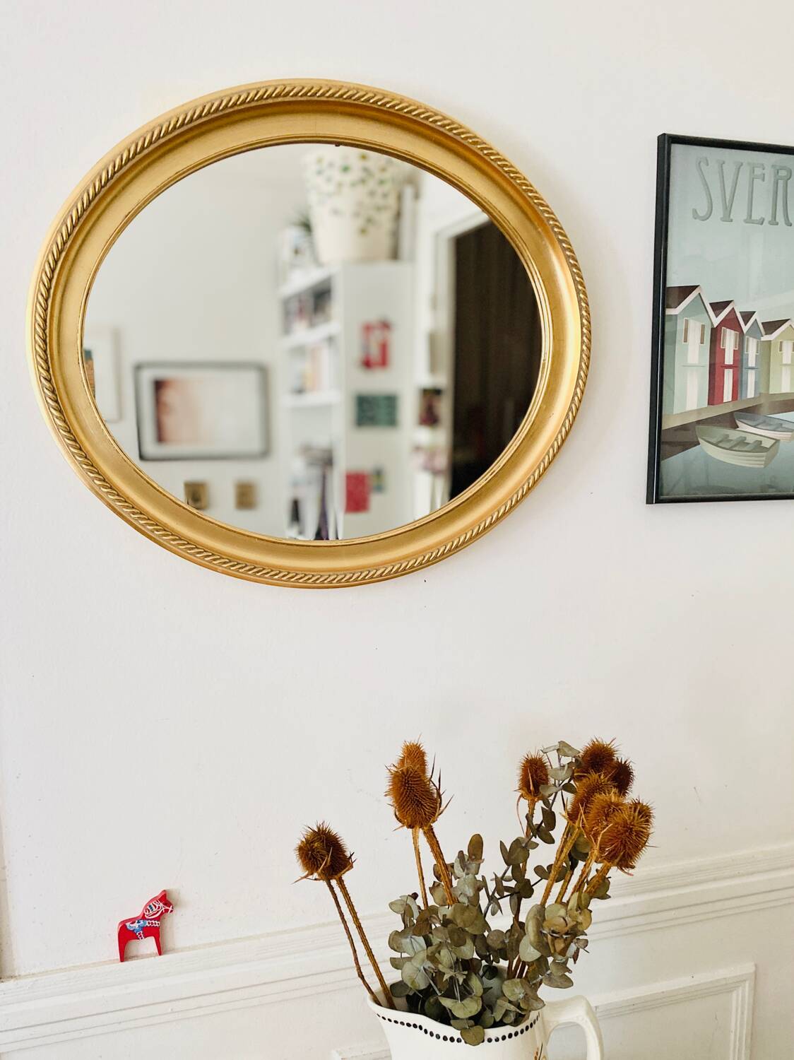 Oval wall mirror in gilded wood