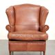Light cognac-coloured cow leather wingback armchair with matching piping