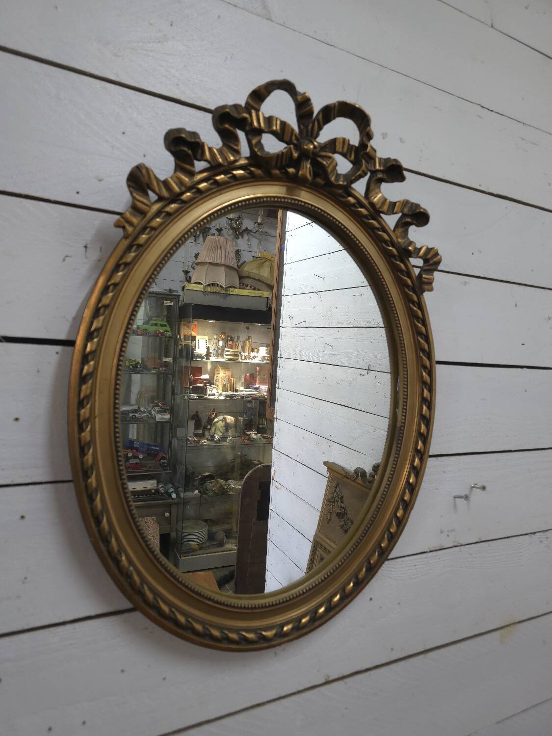 Oval mirror with gold patina