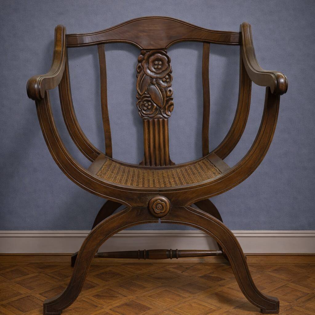 Fauteuil curule de style Art Nouveau en noyer sculpté et assise cannée