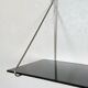 Mid-century vintage shelf in a loop shape, black glass and metal.