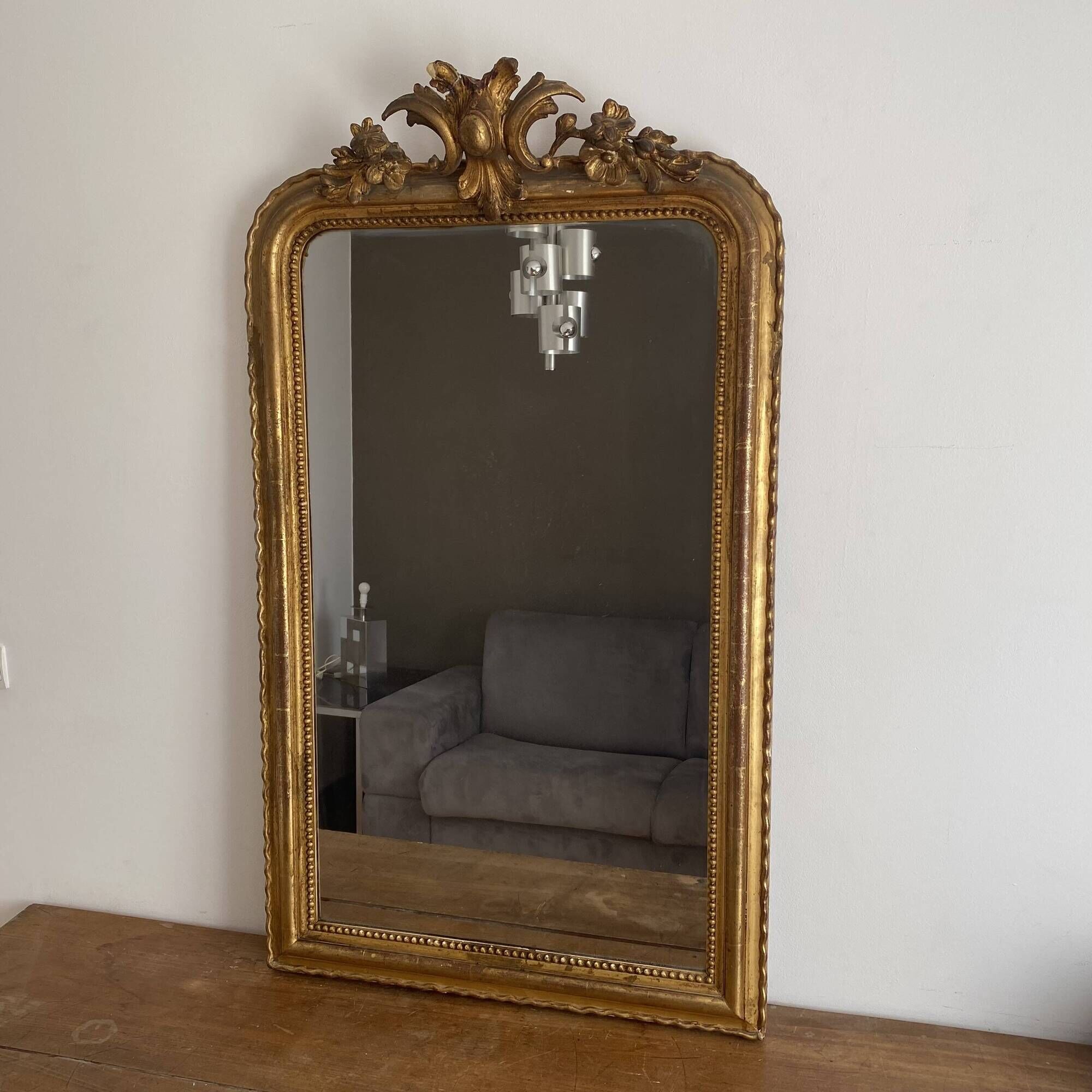 Golden mirror from the late 19th century with a decorated pediment. 130x74.
