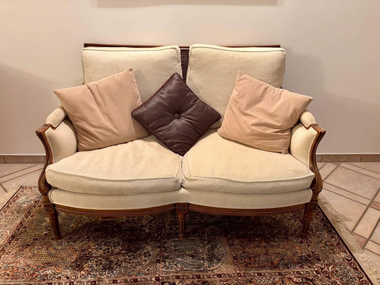 Two-seater canapé by Roche Bobois in Louis XVI style — carved wood, caned sides.