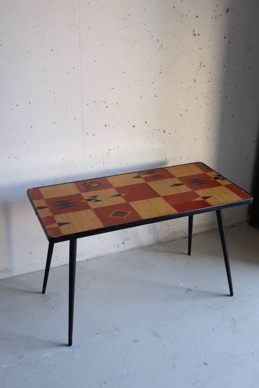 Vintage coffee table in laminate with geometric design, with tapered legs.