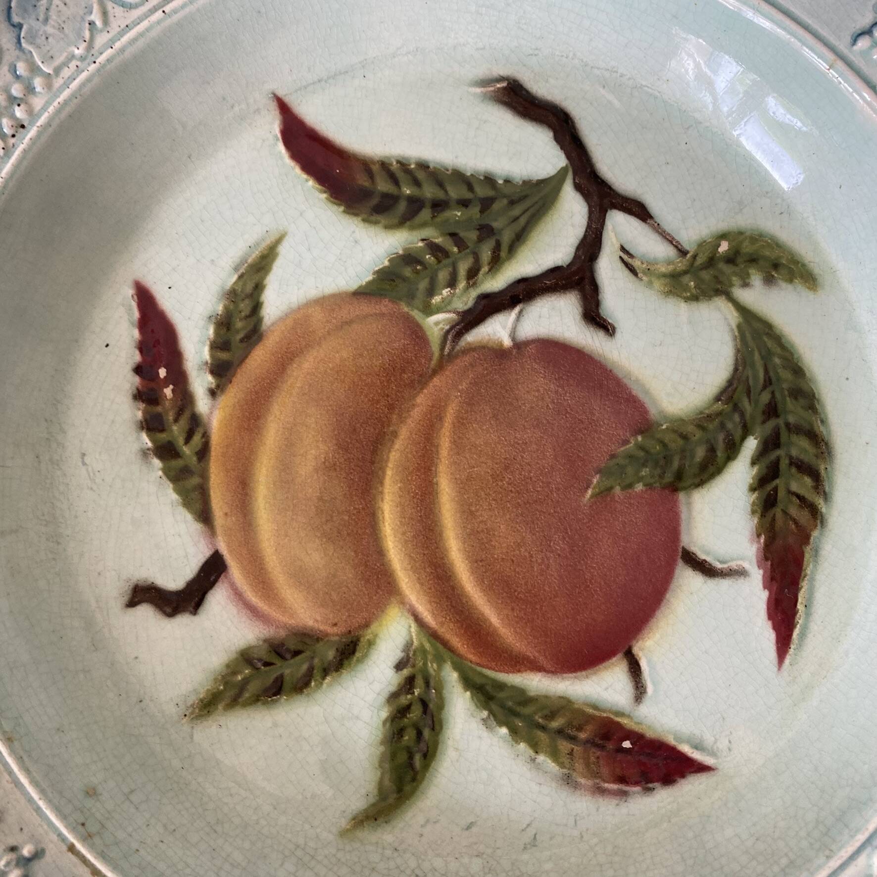 Shallow dish in slip with fruit decoration of peaches.
