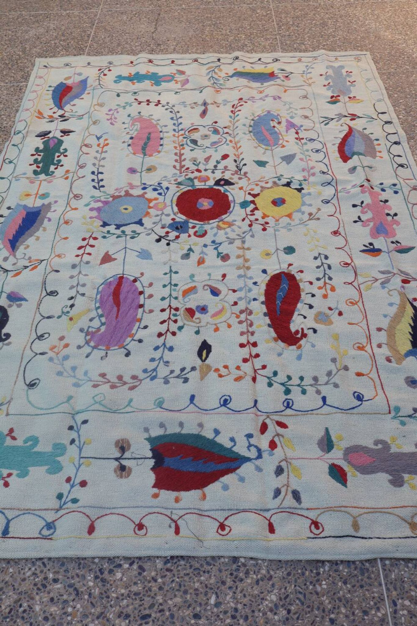 White suzani kilim rug with hand embroidered multi-colored patterns