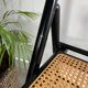 Vintage folding chairs in black wood and cane.