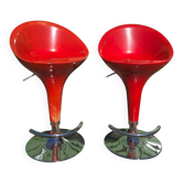 Pair of adjustable red bar stools in resin and chrome.