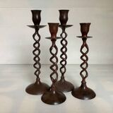 Four twisted metal candle holders with a rusty appearance