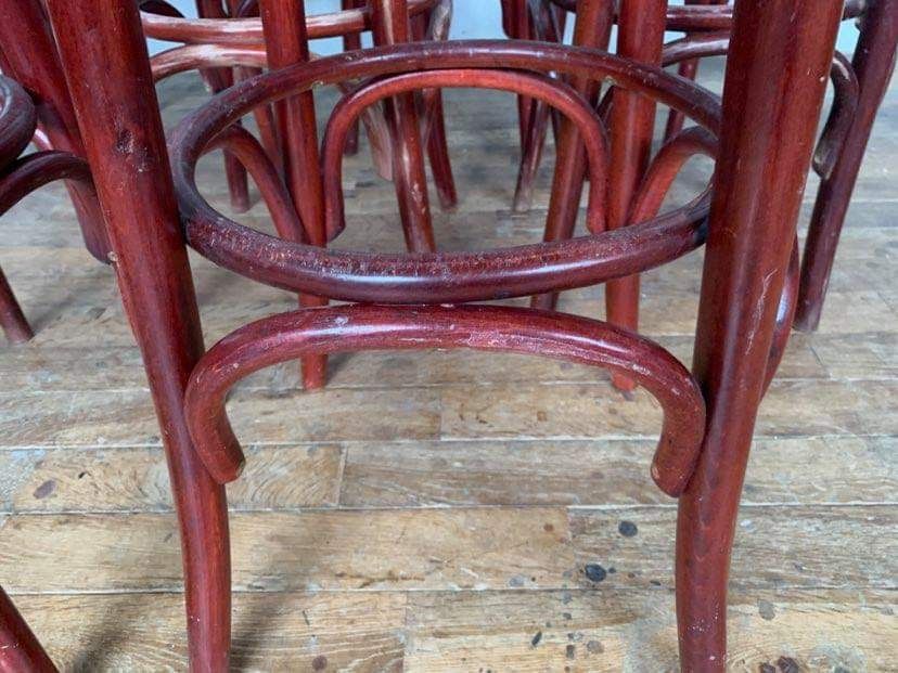 Series of 9 bistro bar stools in curved wooden restaurant sitting red fabric