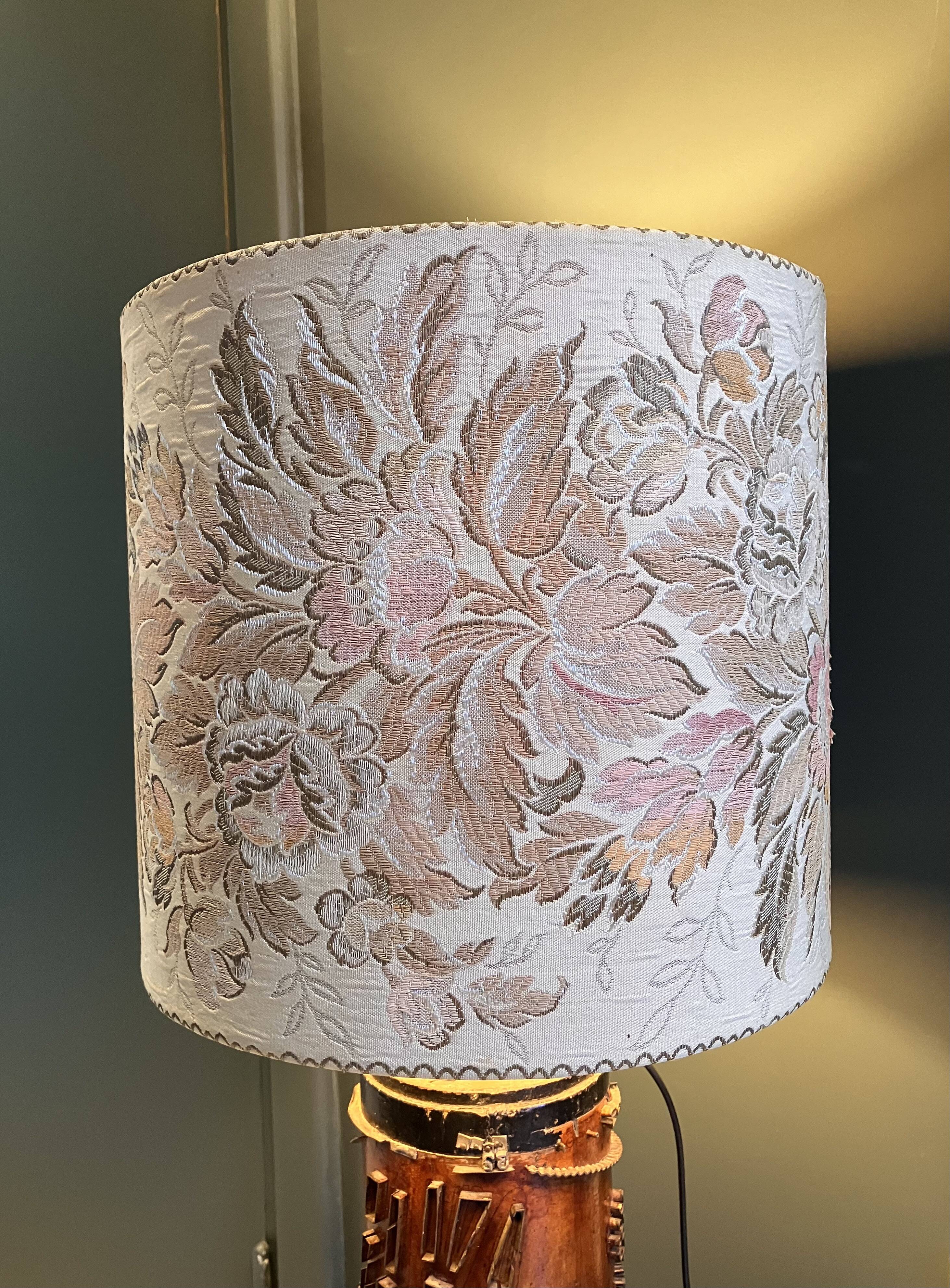 Table lamp with a solid wood printing roll and floral lampshade.