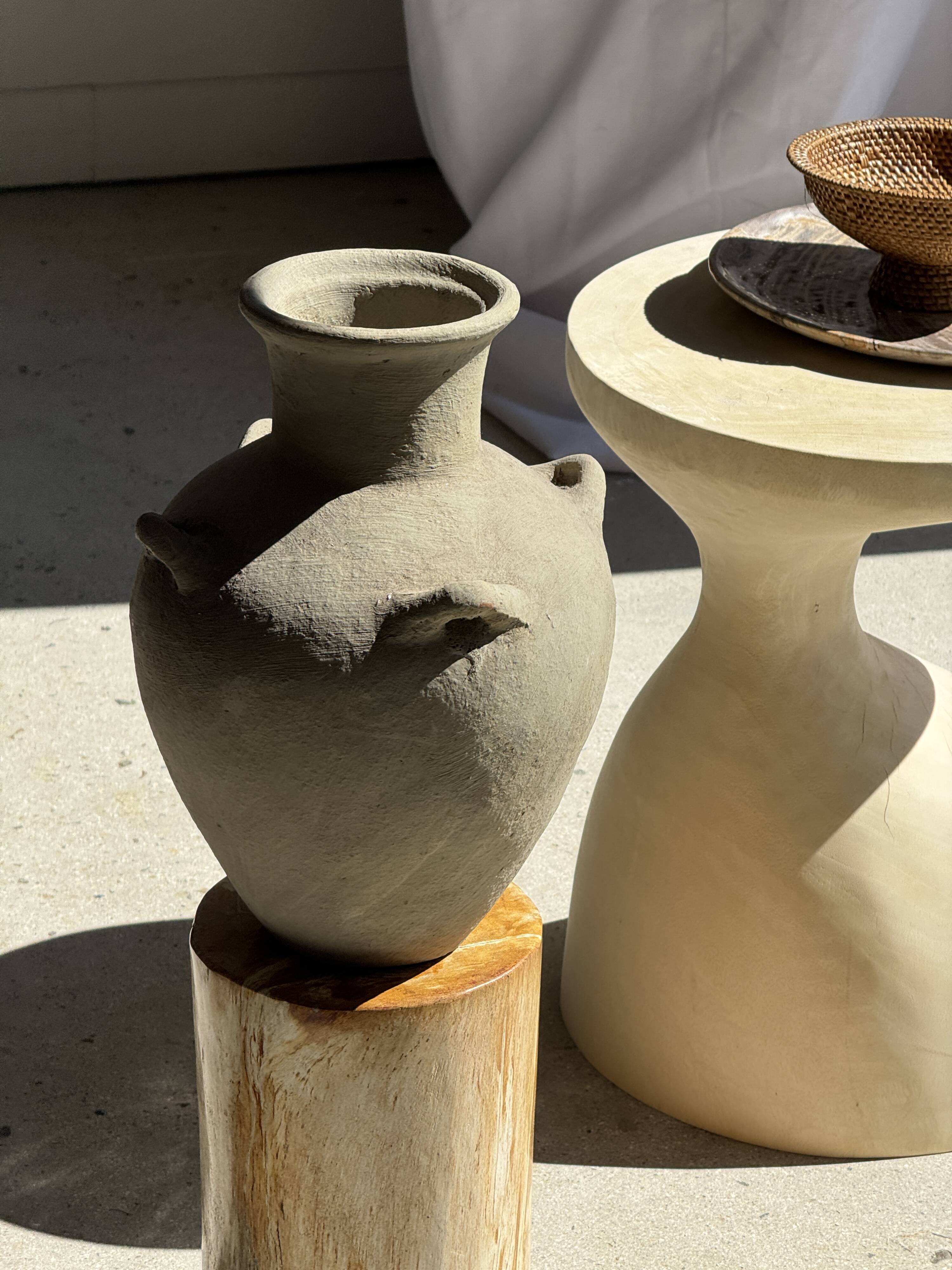 Light beige-grey Indonesian terracotta vase with 4 small handles and a high neck.