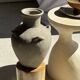 Light beige-grey Indonesian terracotta vase with 4 small handles and a high neck.