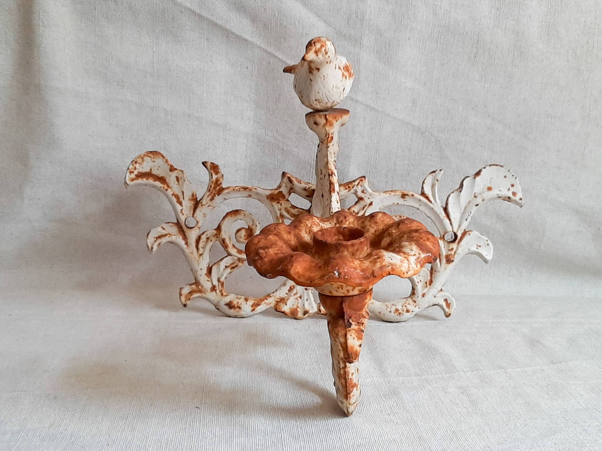 Wall lamp in antique cast iron with bird and scroll decorations.