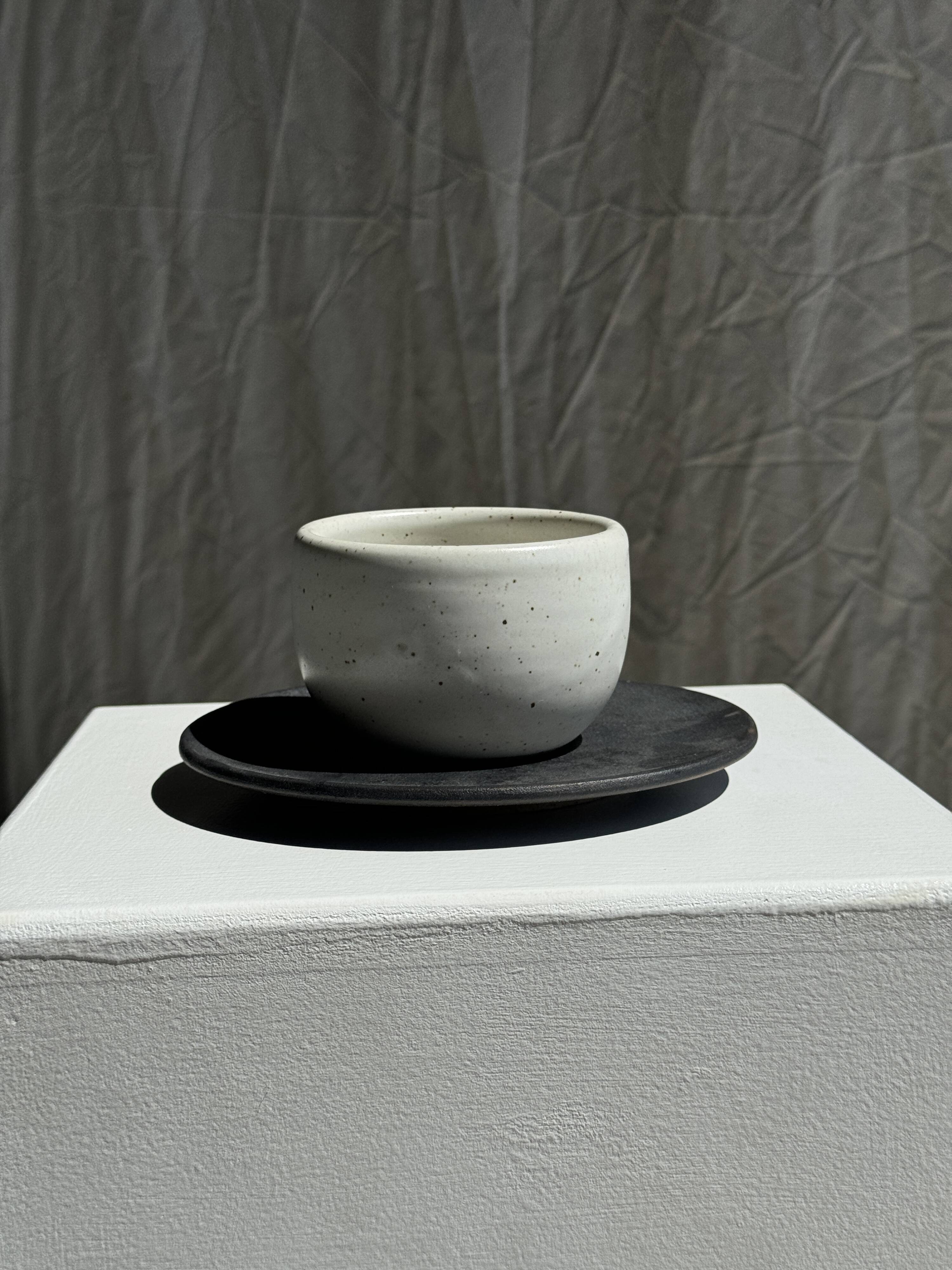 White Indonesian ceramic cup and gray saucer