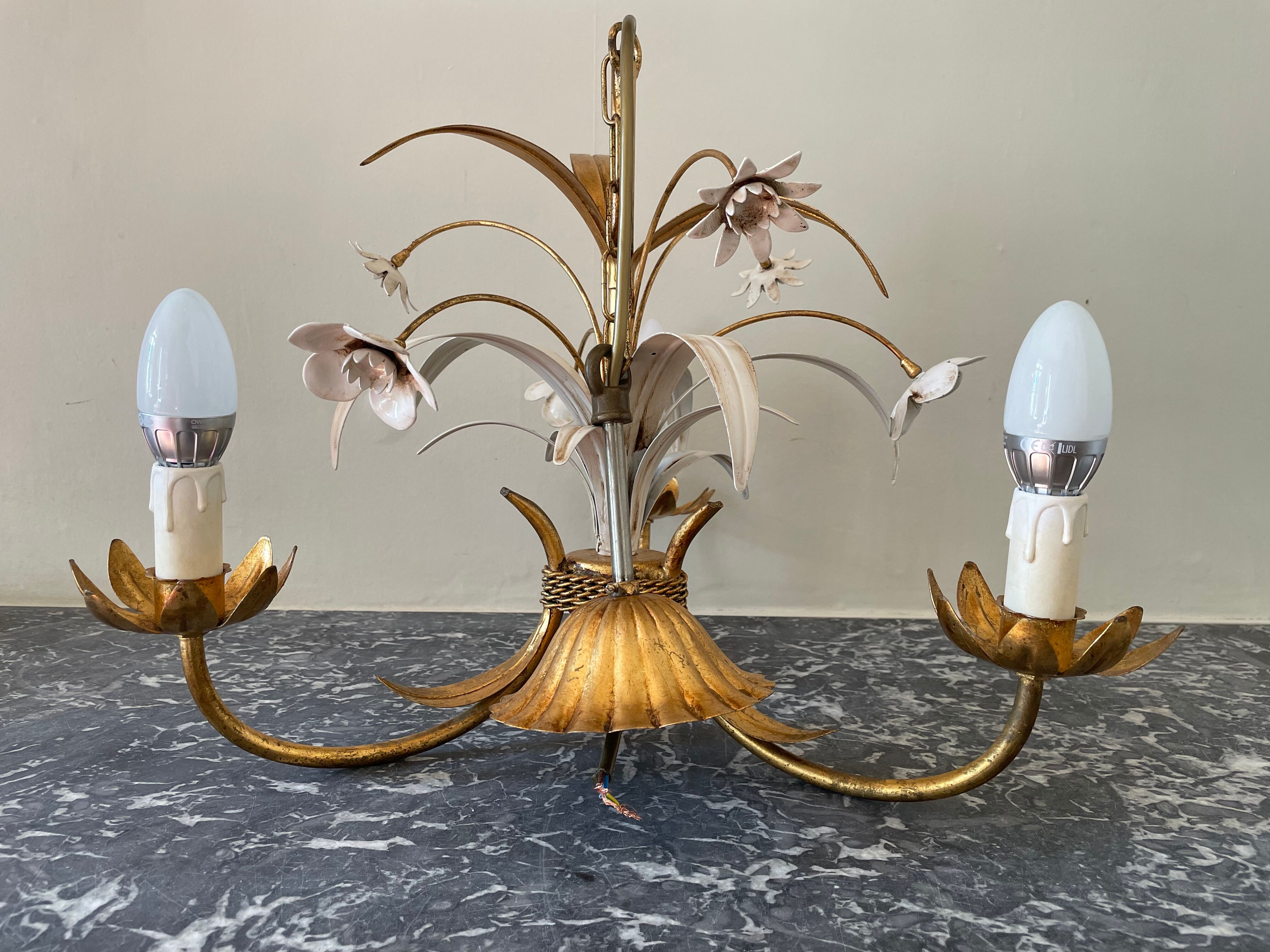 Golden metal chandelier decorated with flowers