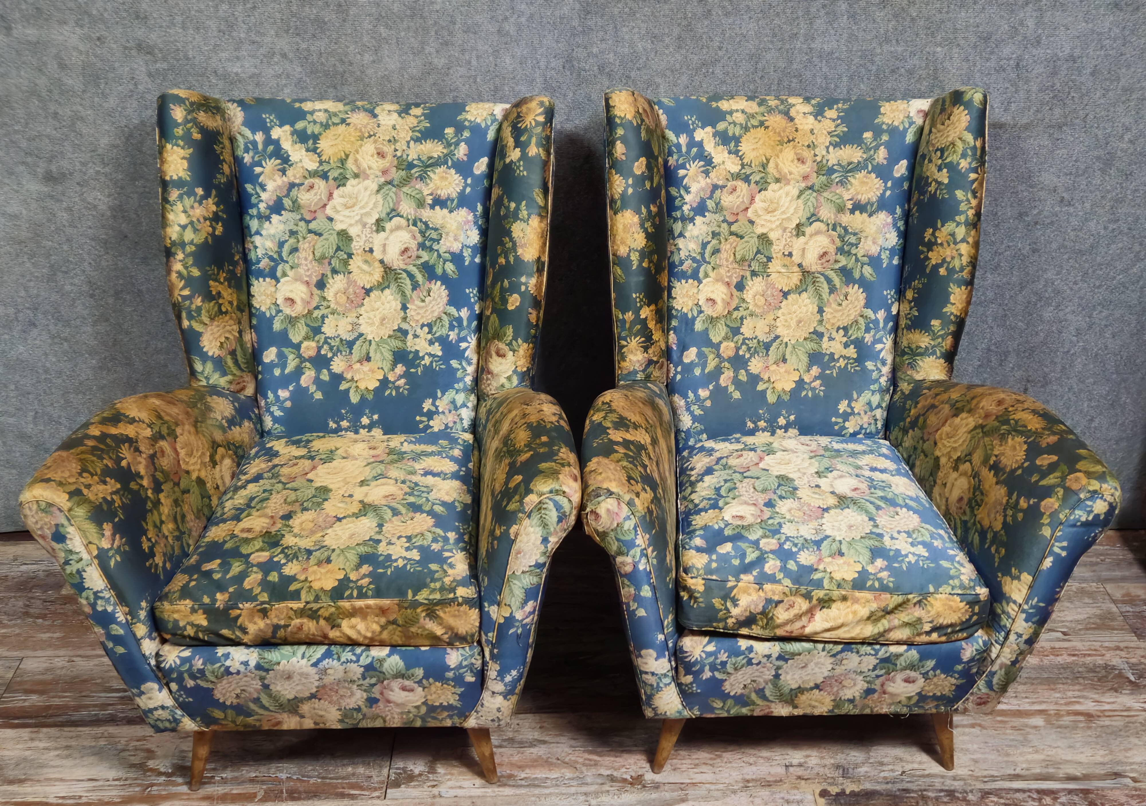 Pair of vintage armchairs with enveloping backrest.
