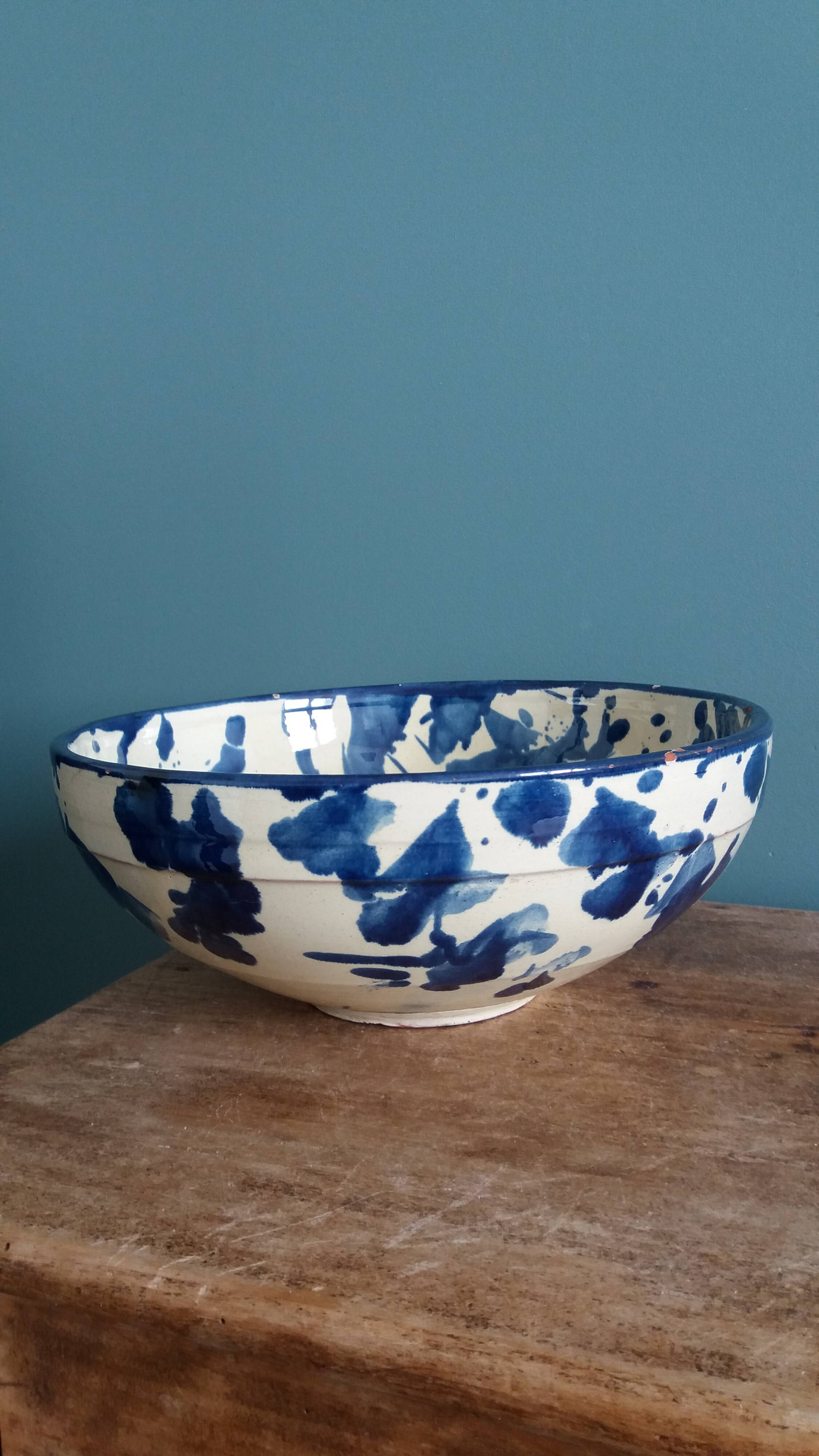 Empty pocket bowl in terracotta, glazed with "ink spots" design.