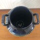 Vase in glazed ceramic decoration drips on blue background