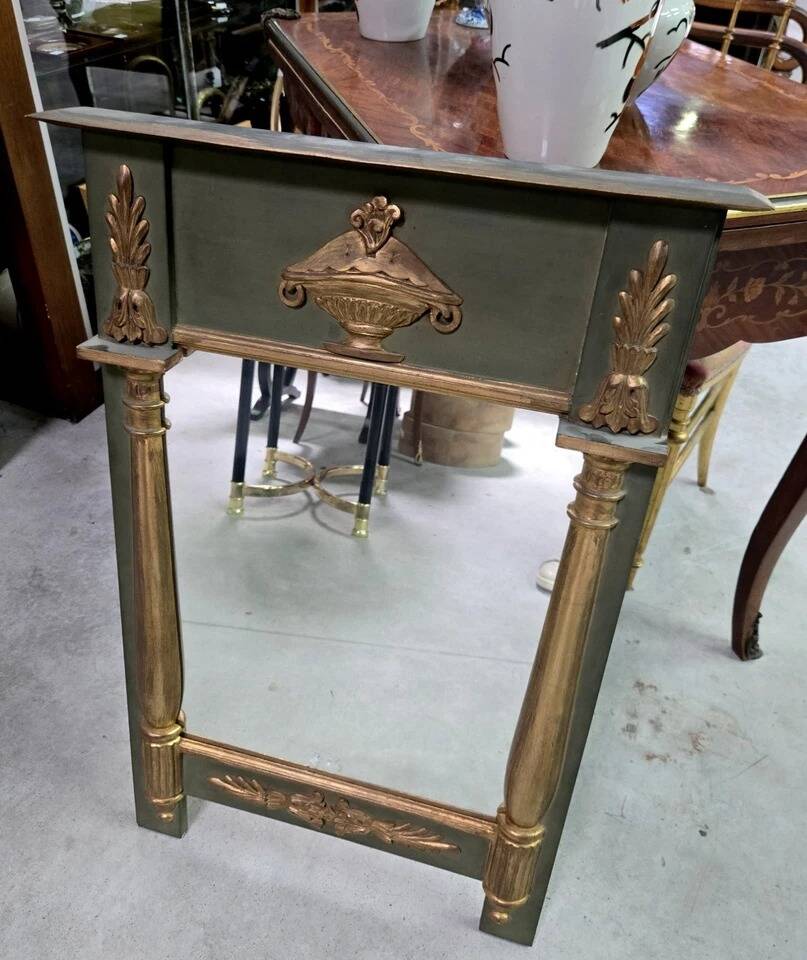 Empire-style mirror in deep green lacquered wood richly enhanced.