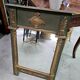 Empire-style mirror in deep green lacquered wood richly enhanced.