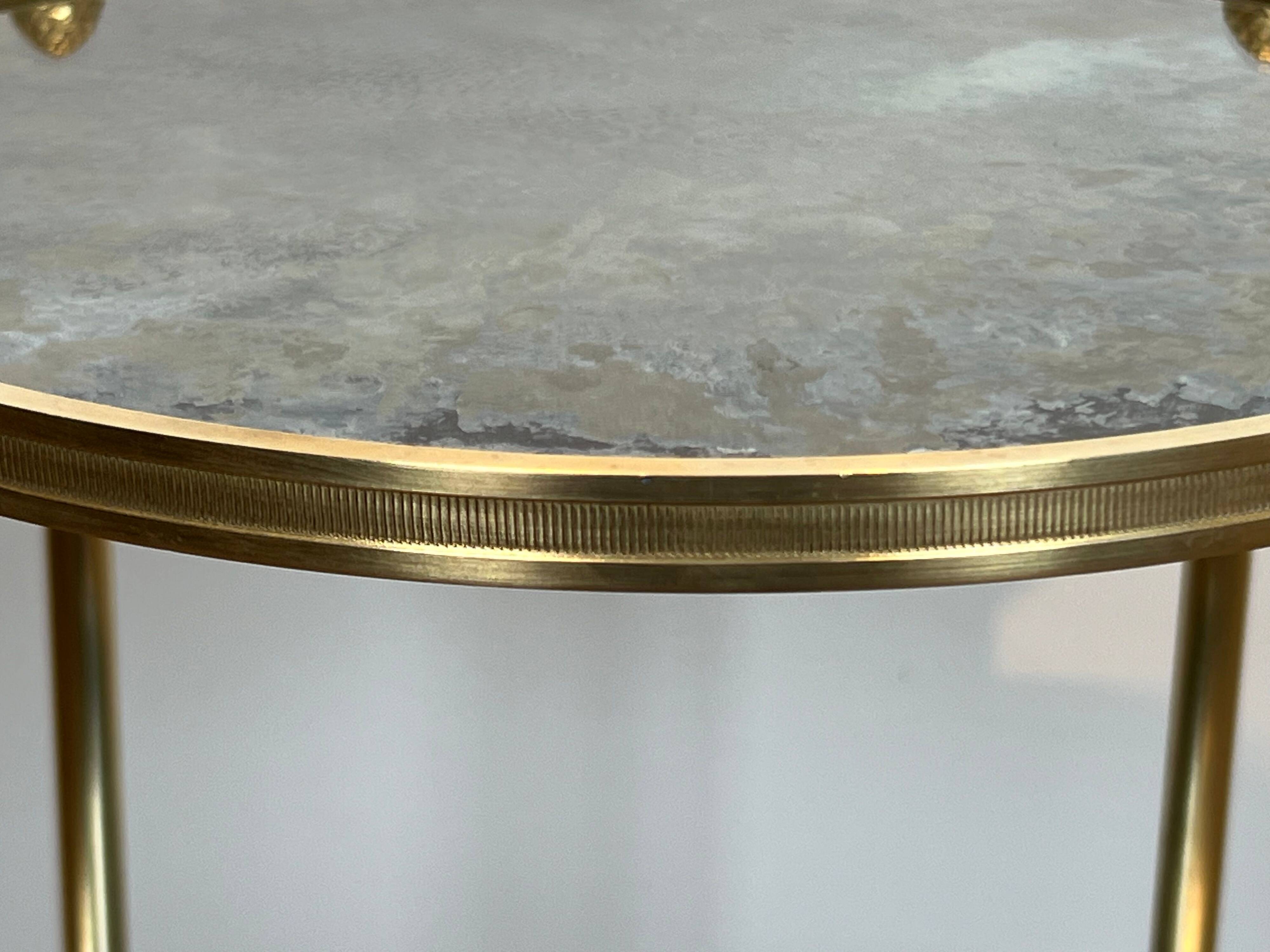 Round bronze side table with triple shelves of églomisé mirrors from Maison Baguès