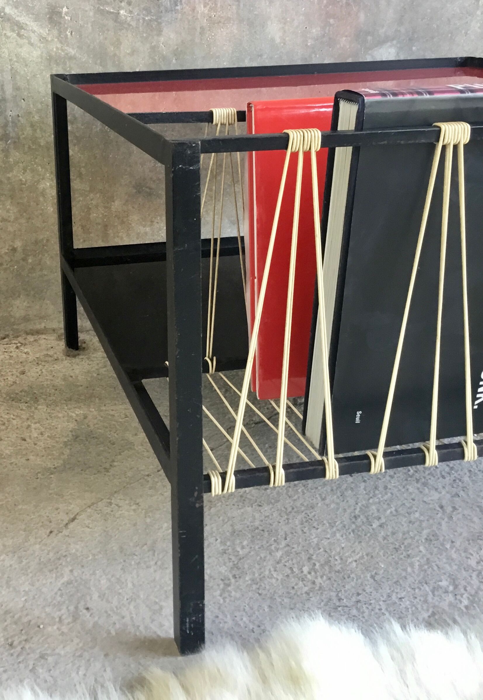 Modernist metal coffee table with a magazine rack in 1950s design.