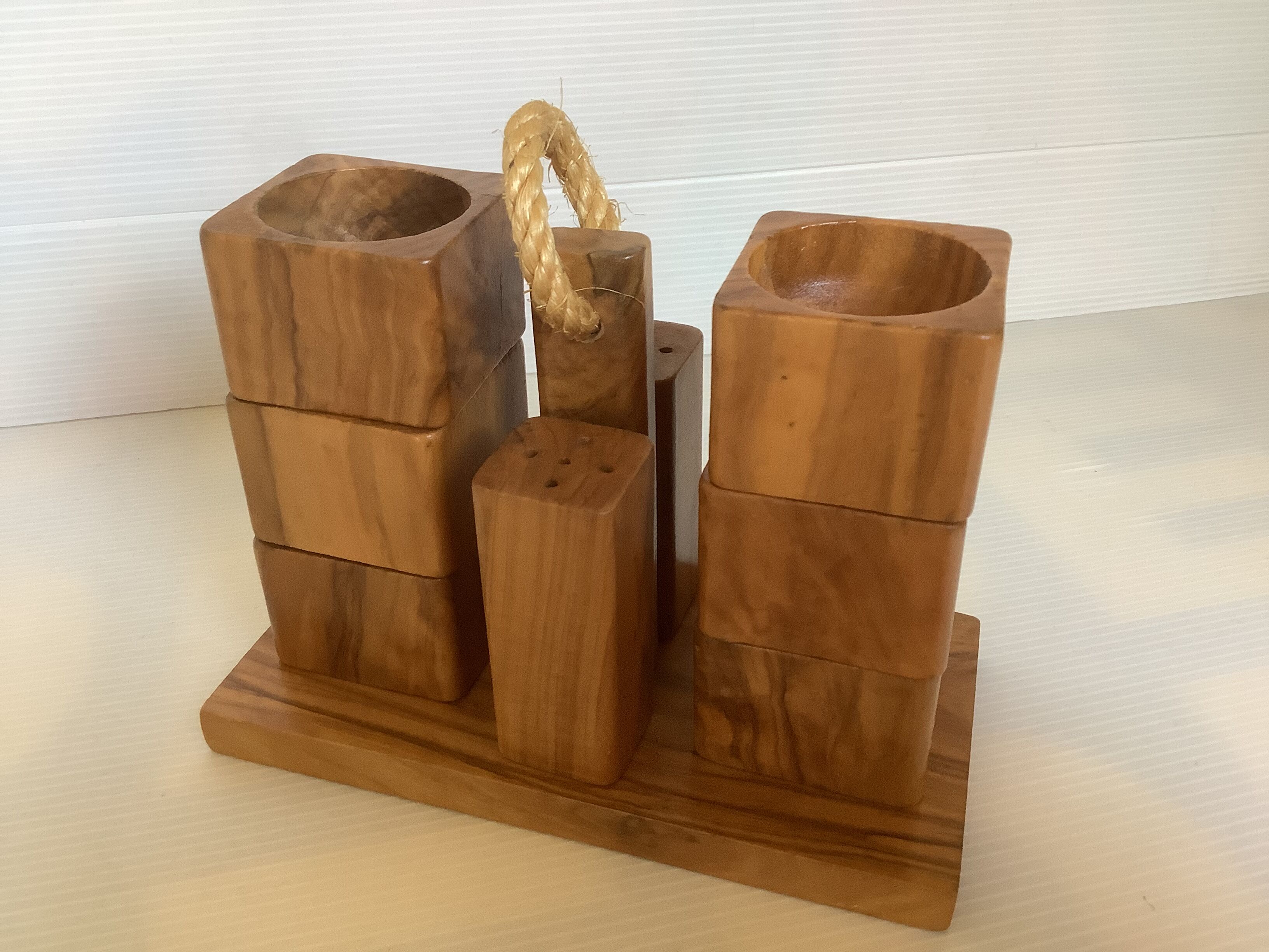 Six olive wood salt and pepper egg cups with their holder.