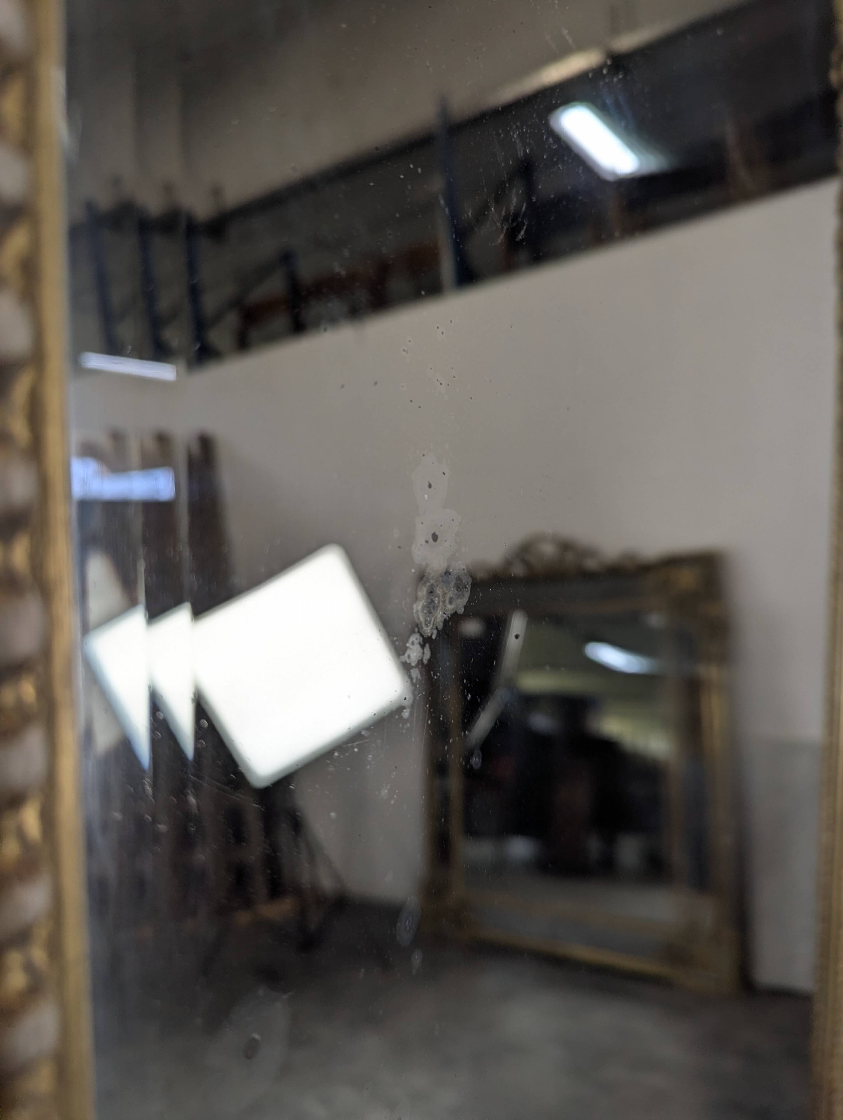 Large gilded wooden mirror in Louis XVI style from the late 19th century.