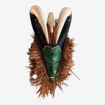 Old tribal mask in wood and raffia fiber