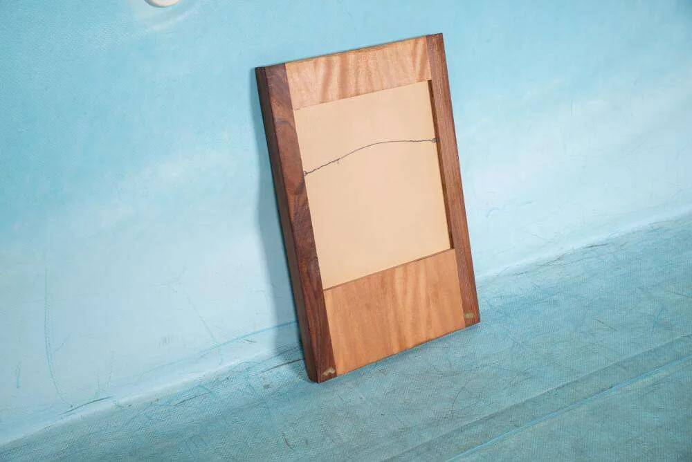 Minimalist Scandinavian mirror in teak with a vintage design.