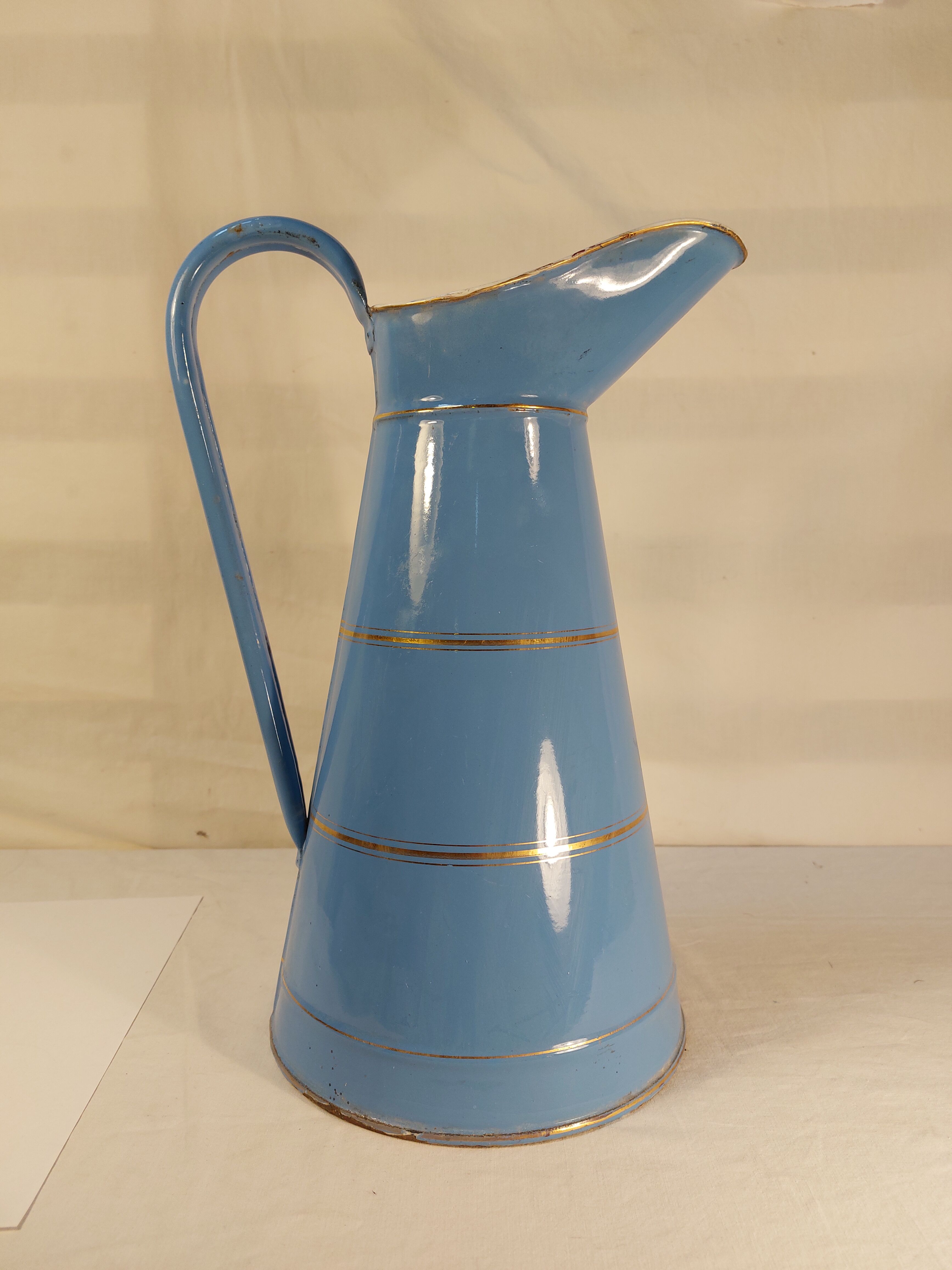 Old jug or water pitcher in blue and gold enamelled sheet metal