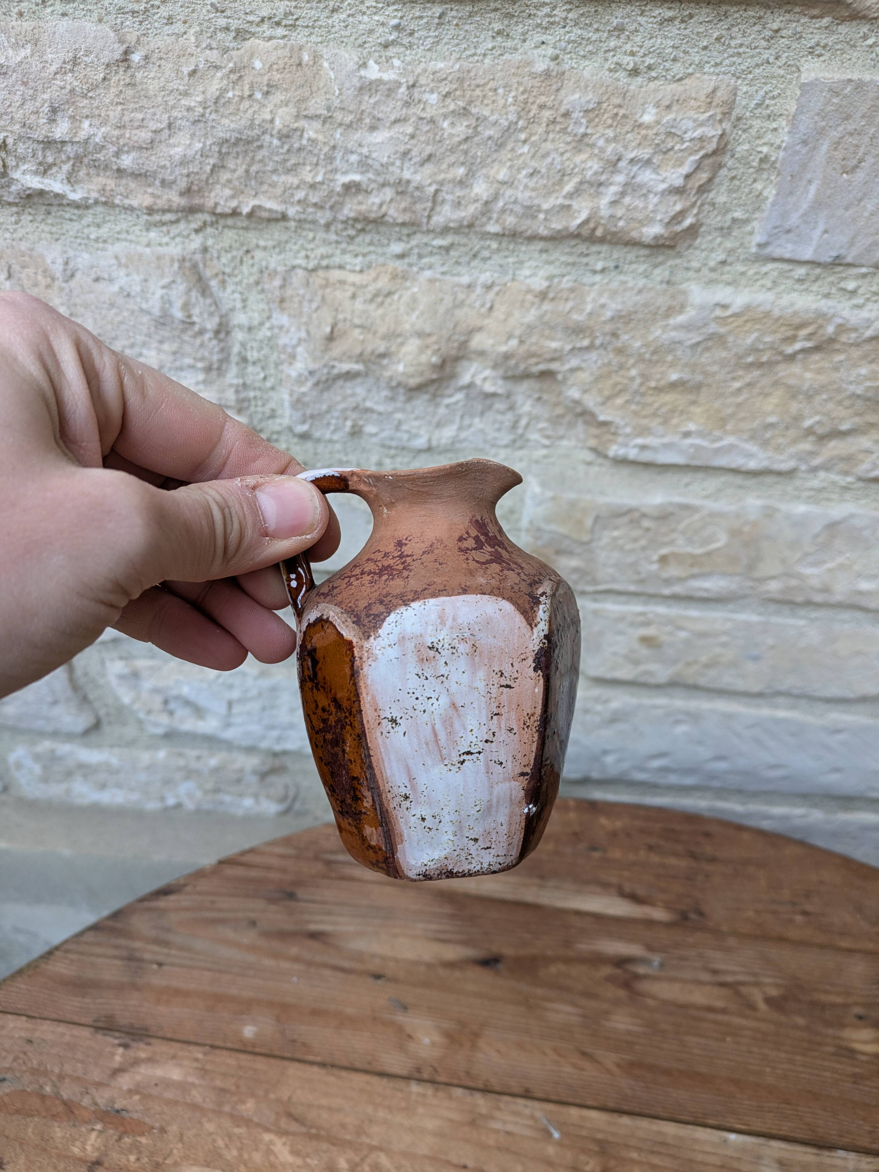 Old small pitcher in glazed terracotta