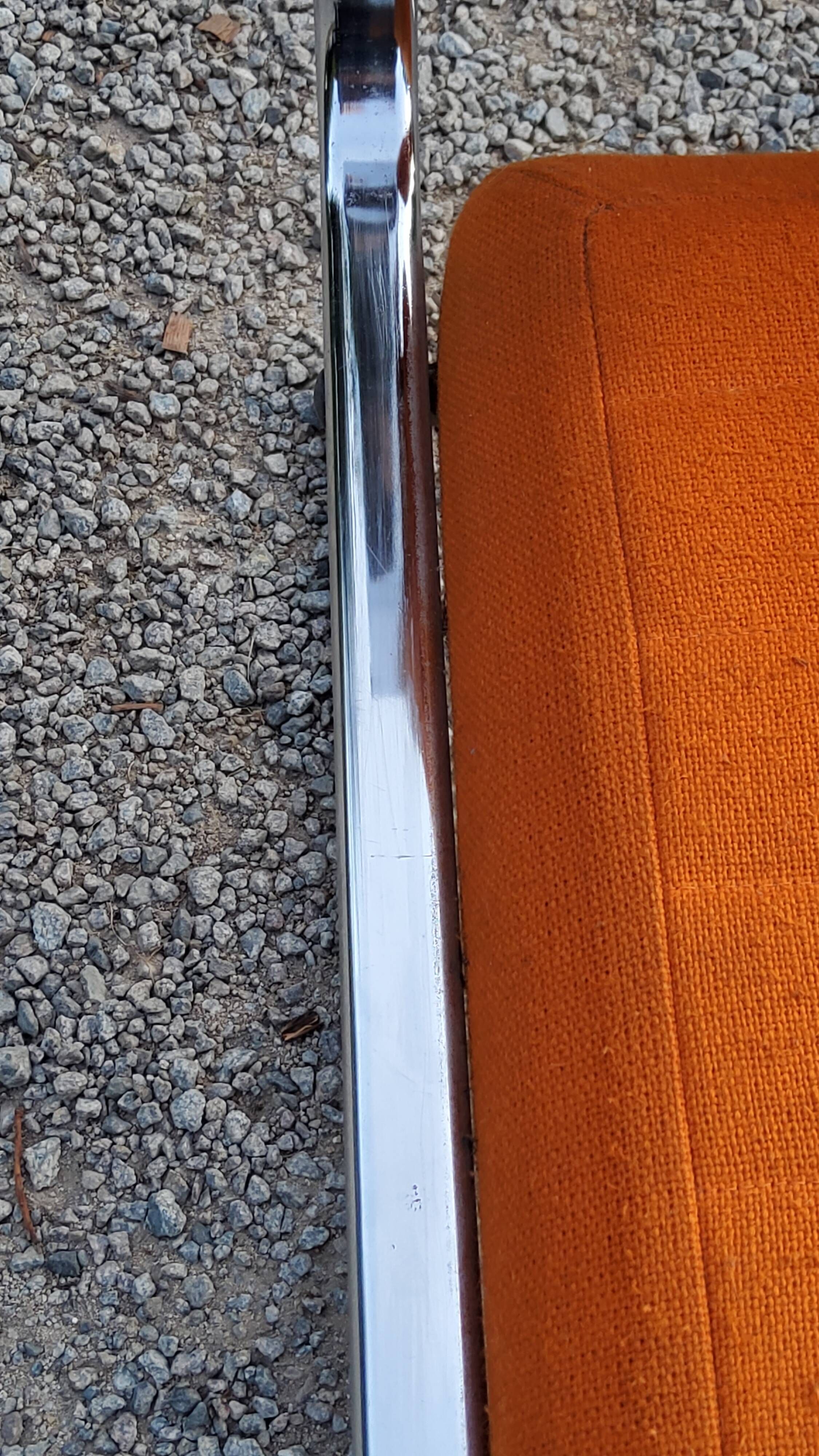 Pair of designer armchairs in orange fabrics and chrome tubes from the 70s