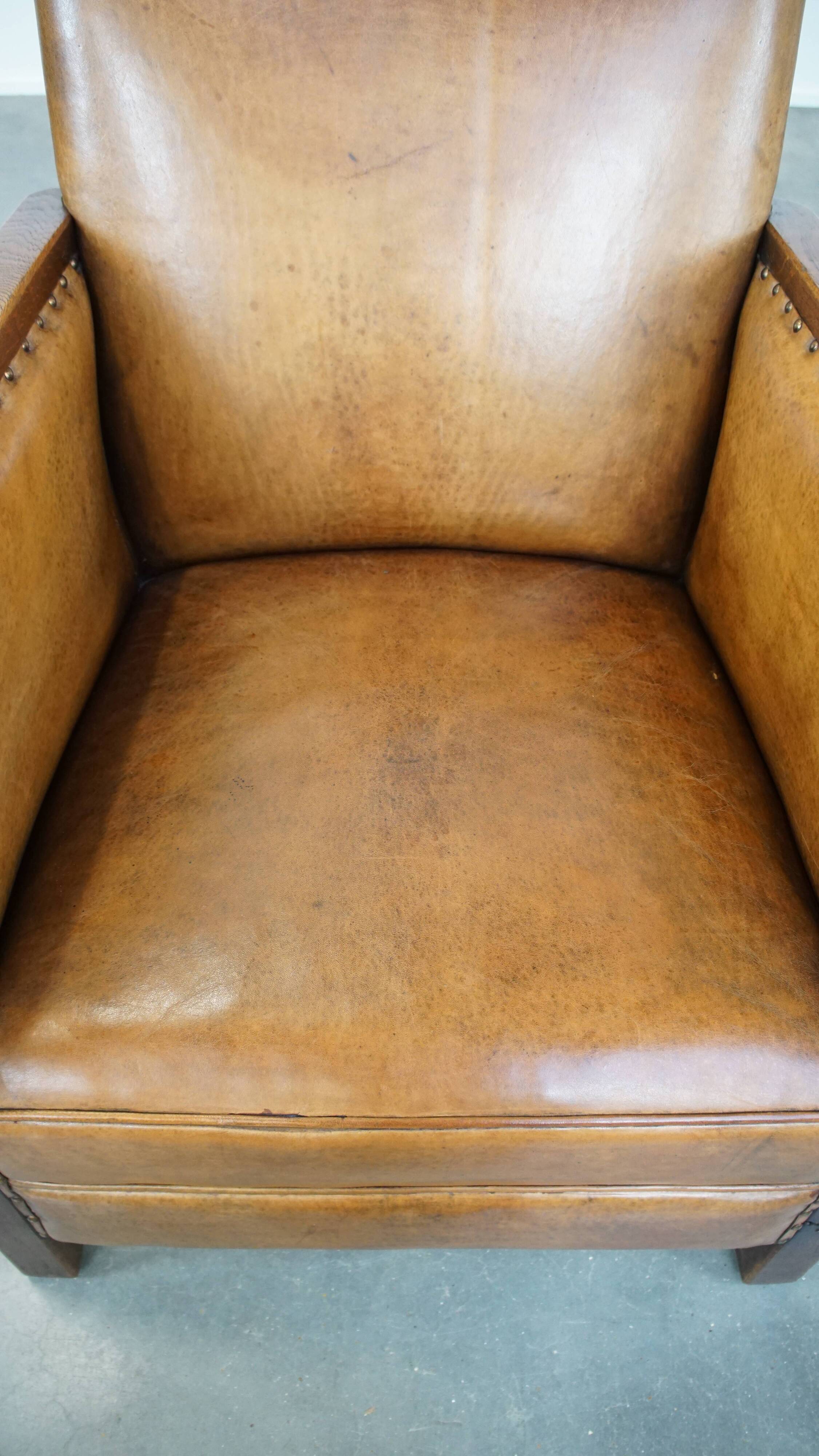 Cognac-colored sheepskin and wooden Art Deco design armchair