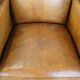 Cognac-colored sheepskin and wooden Art Deco design armchair