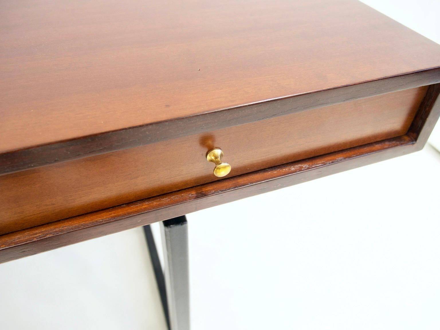Wooden desk with drawers and black lacquered legs.
